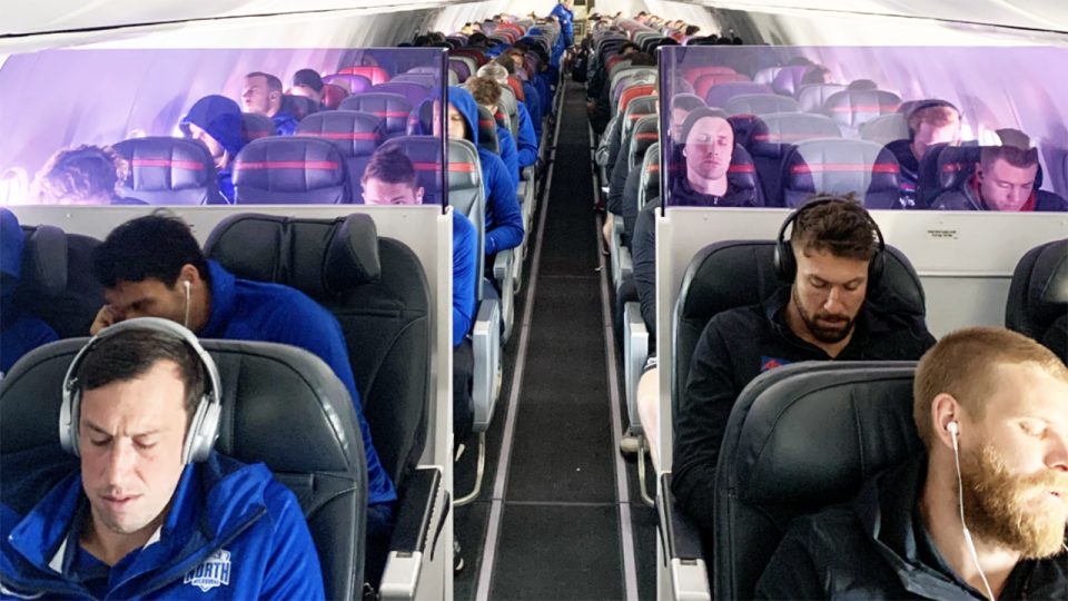 North Melbourne and Essendon players, pictured here sharing a flight to Sydney.