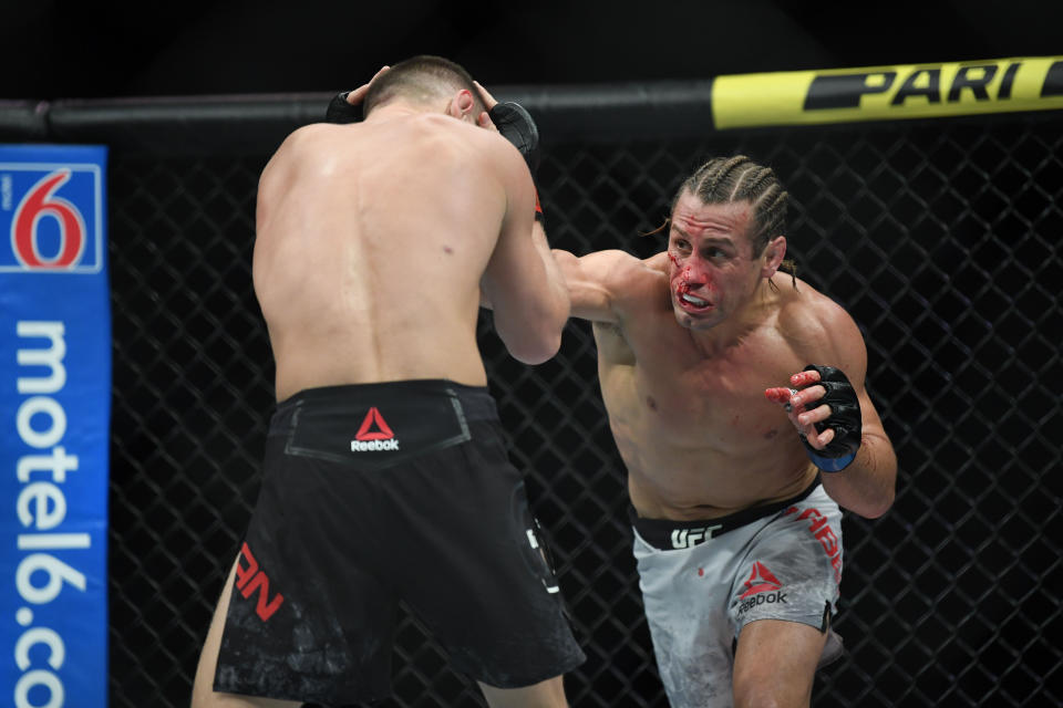 Dec 14, 2019; Las Vegas, NV, USA; (Editor's Note: Graphic Content) Petr Yan (red gloves) fights Urijah Faber (blue gloves) during UFC 245 at T-Mobile Arena. Mandatory Credit: Stephen R. Sylvanie-USA TODAY Sports