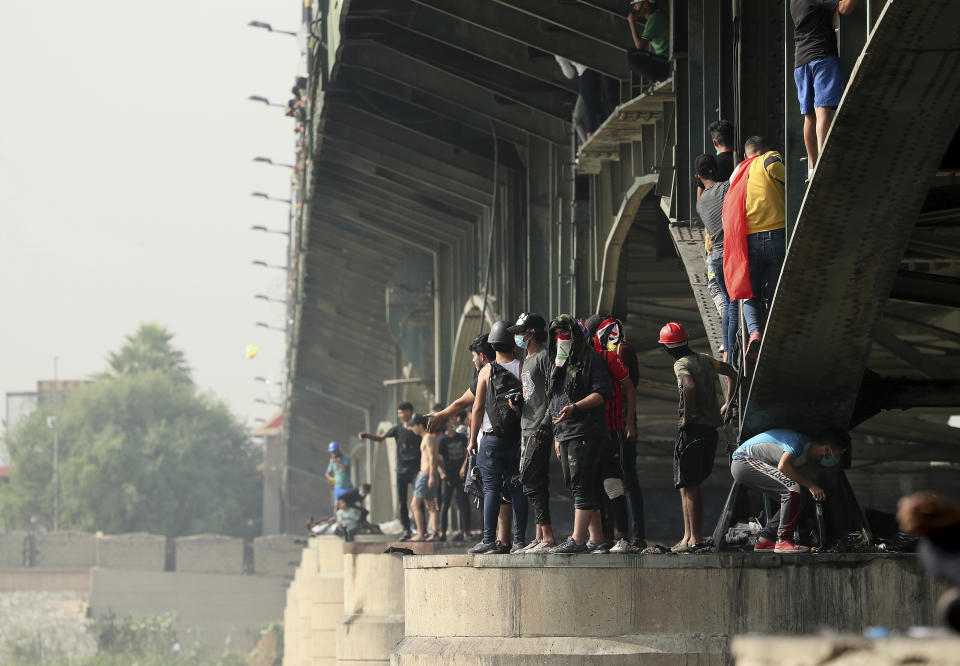 Protesters stand on the Joumhouriya Bridge that leads to the Green Zone government area, during ongoing anti-government protests in Baghdad, Iraq, Sunday, Nov. 3, 2019. (AP Photo/Hadi Mizban)