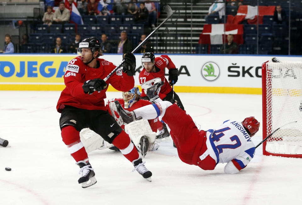 Switzerland's Kevin Romy, left, battles for the puck during the Group B preliminary round match between Switzerland and Russia at the Ice Hockey World Championship in Minsk, Belarus, Friday, May 9, 2014. (AP Photo/Darko Bandic)