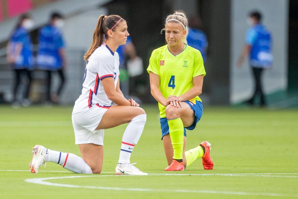 Alex Morgan, of US, and Hanna Glas, of Sweden, take a knee at Tokyo Stadium (Corbis via Getty Images)