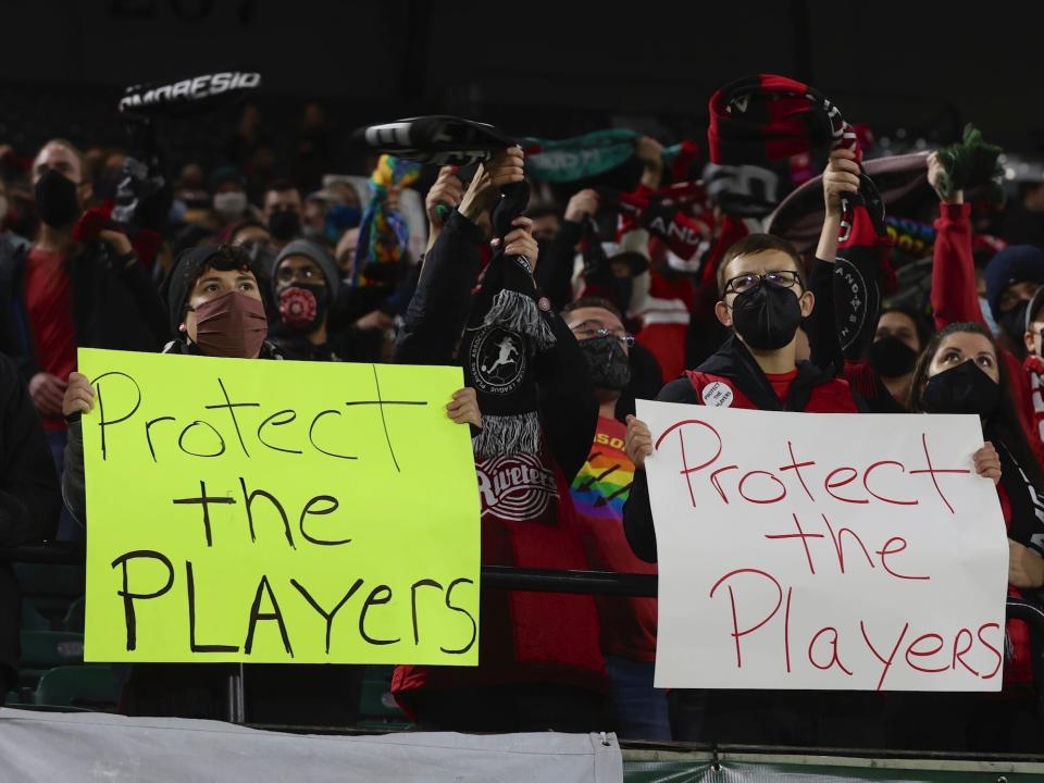 Portland Thorns fans hold "Protect the Players" signs at a game against the Houston Dash.