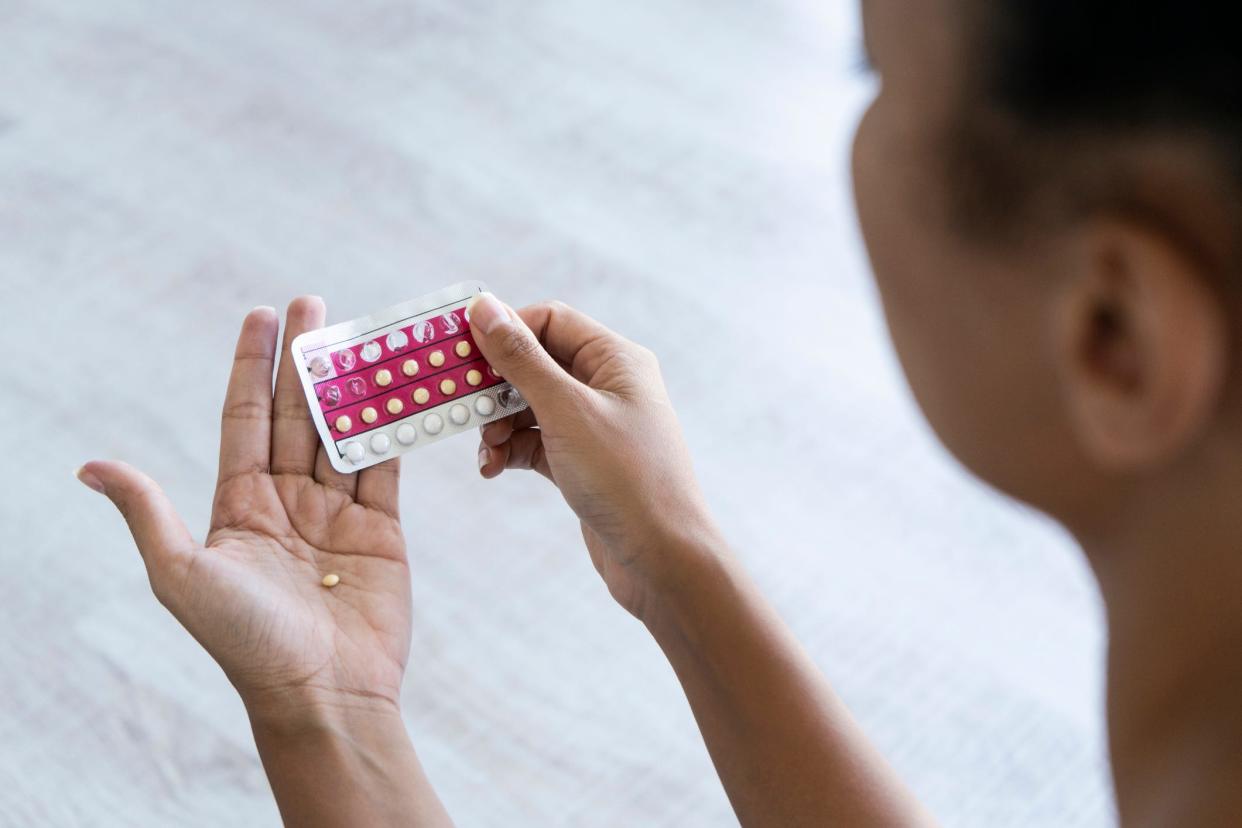 A woman taking the pill.