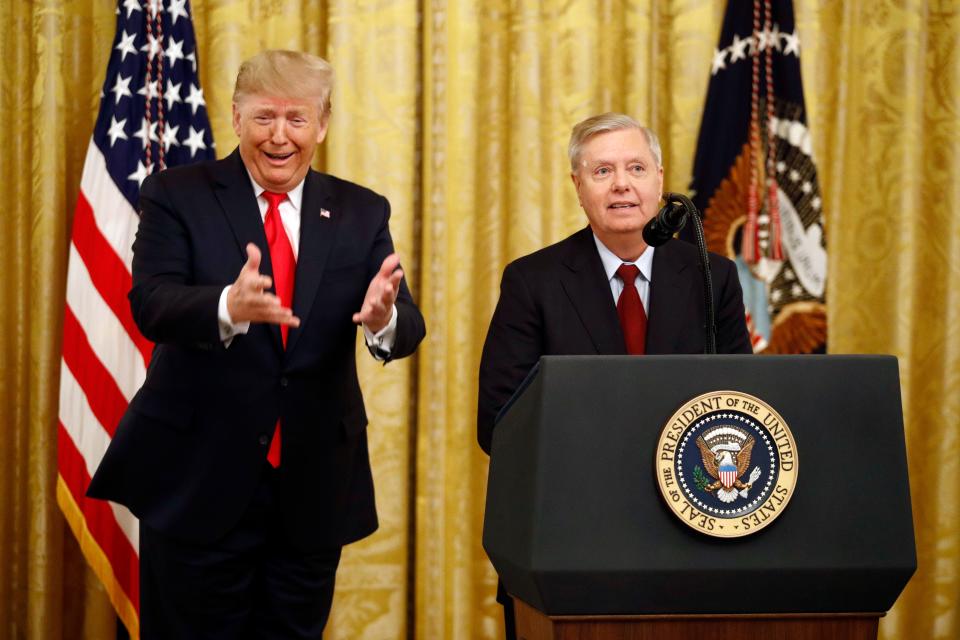 President Donald Trump gestures as Sen. Lindsey Graham, R-S.C., speaks about an upcoming afternoon vote in the Senate during an event in the East Room of the White House about Trump's judicial appointments, Nov. 6, 2019, in Washington.