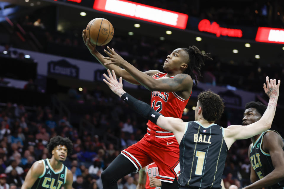 Chicago Bulls guard Ayo Dosunmu drives to the basket past Charlotte Hornets guard LaMelo Ball (1) during the first half of an NBA basketball game in Charlotte, N.C., Thursday, Jan. 26, 2023. (AP Photo/Nell Redmond)
