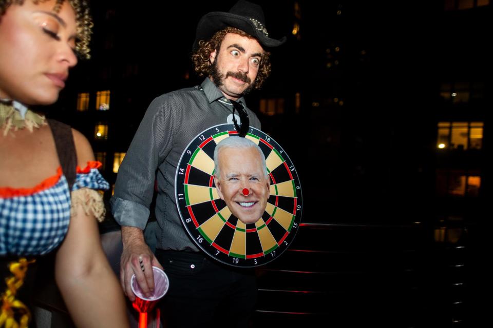 <br>An attendee wears a dartboard featuring President Joe Biden’s face at the <br>MAGAween party, where there was a category for “best nonbinary costume.”