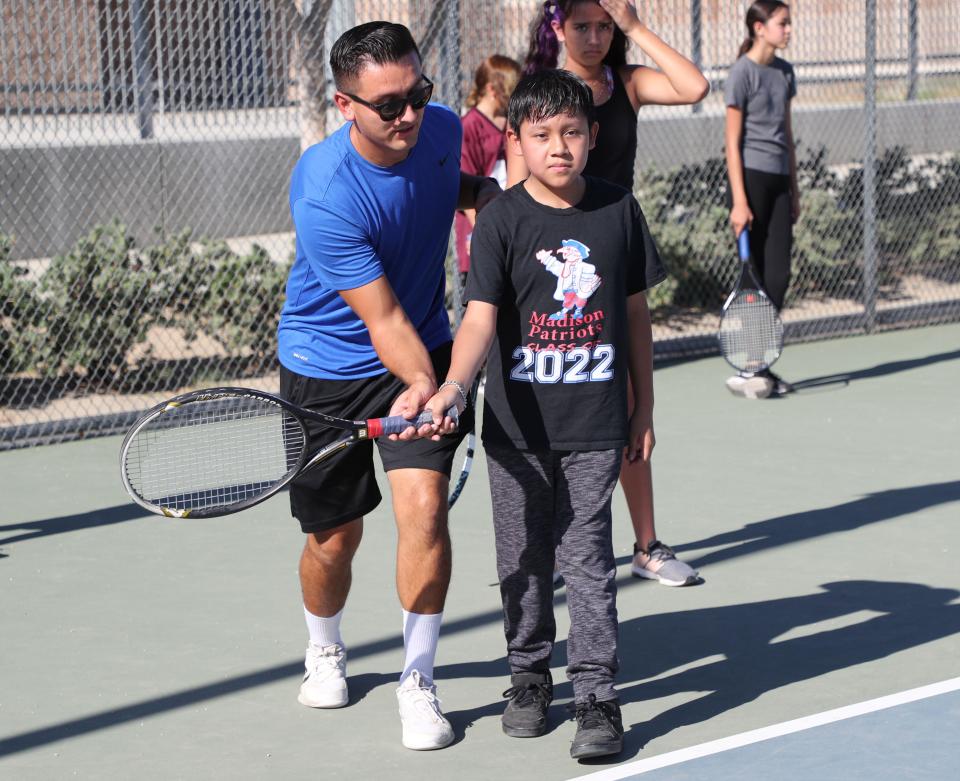 Indio High School tennis coach Mike Nolasco, left, instructs one of the students during a tennis clinic at Indio High School, July 6, 2022.  