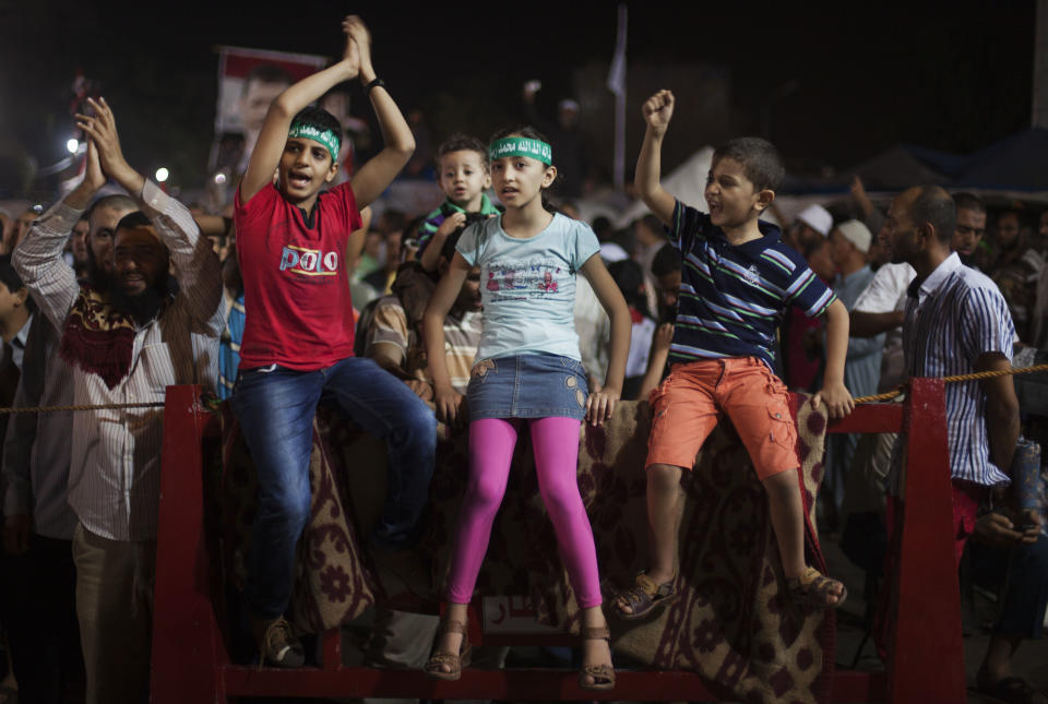 Egyptian children wear head bands with Arabic writing reads: "No god but Allah and Mohammed is the prophet," attend a protest outside Rabaah al-Adawiya mosque, where supporters of Egypt's ousted President Mohammed Morsi have installed a camp and hold daily rallies at Nasr City in Cairo, Egypt, Thursday, Aug. 1, 2013. (AP Photo/Khalil Hamra)