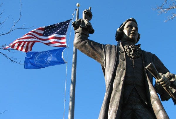 High winds whip the flags above the statue of Barnstable-born patriot James Otis on Route 6A in Barnstable. File photo