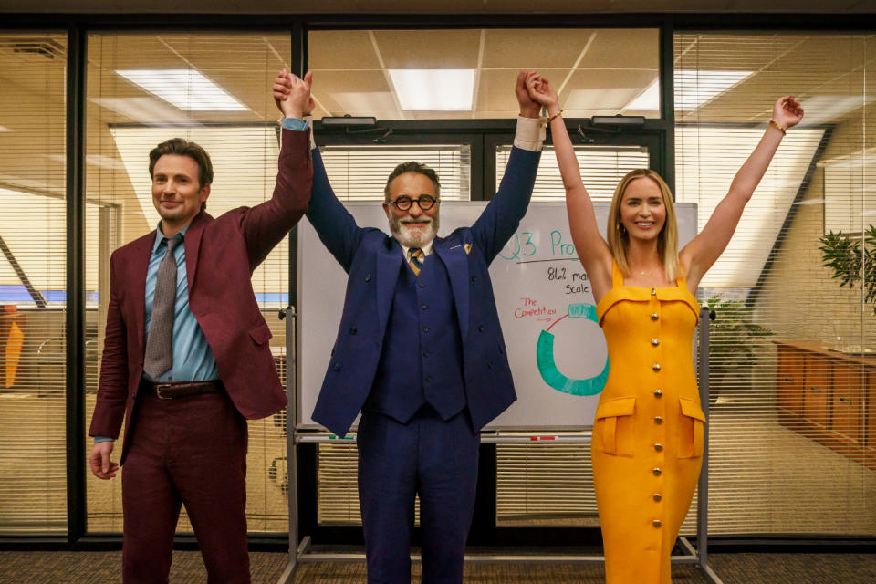 three people holding hands with their hands up in victory