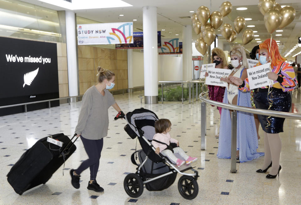 Passengers from New Zealand are welcomed by drag queens as they arrive at Sydney Airport in Sydney, Australia, Monday, April 19, 2021, as the much-anticipated travel bubble between Australia and New Zealand opens. (AP Photo/Rick Rycroft)