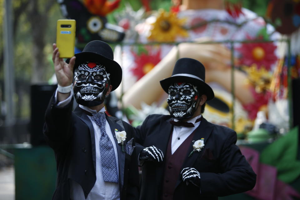 Gabino Pacheco se toma una foto junto a su esposo David Pacheco durante el desfile del Día de Muertos en la Ciudad de México, el sábado 29 de octubre de 2022. (AP Foto/Ginnette Riquelme)