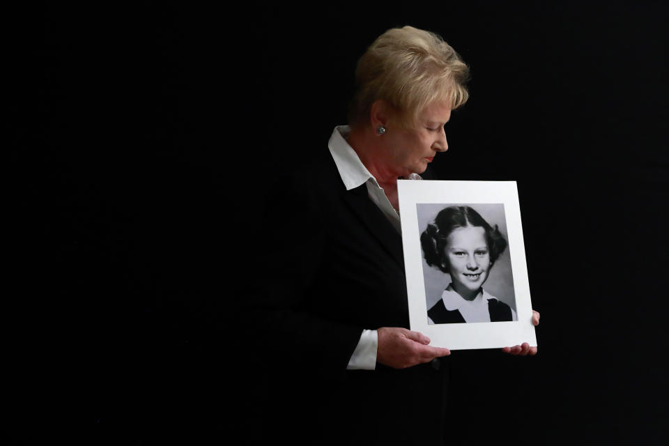 In this Nov. 20, 2019, photo, Nancy Holling-Lonnecker, 71, poses with a picture taken of her as a young girl, at her home in San Diego. Holling-Lonnecker plans to take advantage of an upcoming three-year window in California that allows people to make claims of sexual abuse no matter how old. Her claim dates back to the 1950s when she says a priest repeatedly raped her in a confession booth beginning when she was 7 years old. “The survivors coming forward now have been holding on to this horrific experience all of their lives,” she said. (AP Photo/Gregory Bull)