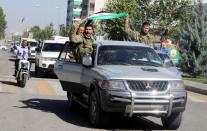 Members of Syrian National Army, known as Free Syrian Army, wave a flag as they drive to cross into Syria in the Turkish border town of Akcakale