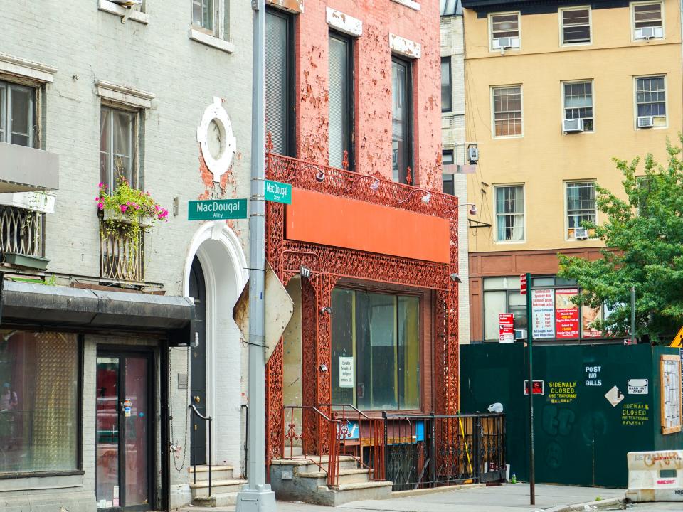 Buildings behind a street sign for MacDougal.