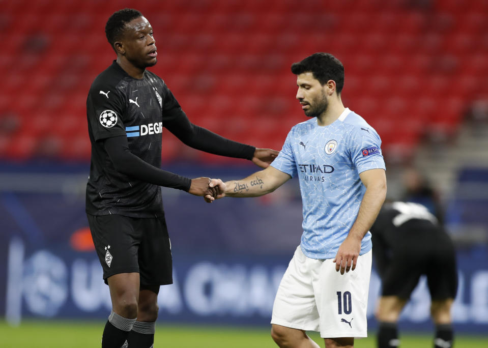 Moenchengladbach's Denis Zakaria, left, and Manchester City's Sergio Aguero shake hands following the Champions League round of 16 second leg soccer match between Manchester City and Borussia Moenchengladbach at the Puskas Arena in Budapest, Hungary, Tuesday, March 16, 2021. (AP Photo/Laszlo Balogh)