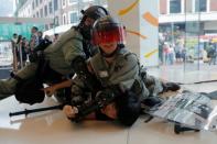 Riot police officers detain an anti-government protester in Tsuen Wan, near the site where police shot a protester with live ammunition on China's National Day in Hong Kong