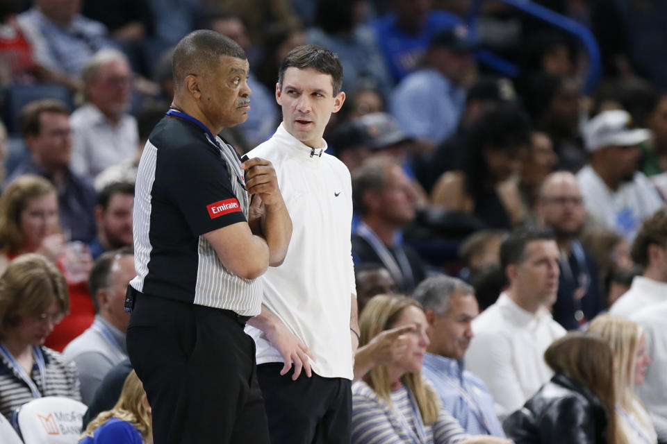 Oklahoma City Thunder coach Mark Daigneault, right, talks to official Tony Brothers, left, during the second half of an NBA basketball game against the Milwaukee Bucks, Friday, April 12, 2024, in Oklahoma City. (AP Photo/Nate Billings)