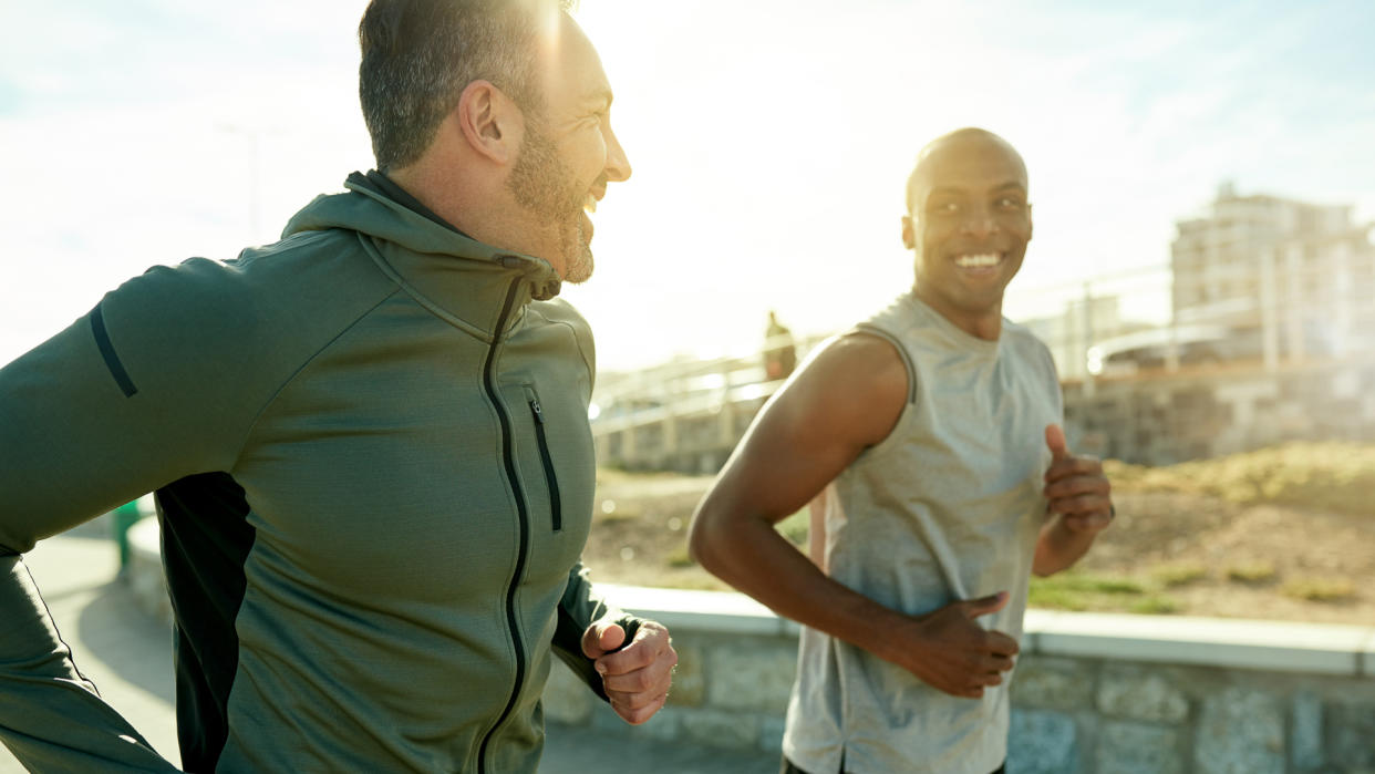 Shot of two sporty men exercising together outdoors.