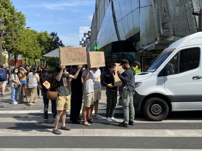 中國旅法學生2022年7月23日在巴黎香榭大道抗議迪奧（Dior）新裙設計「文化挪用」抄襲漢服，現場出現反示威活動是由法國「反賊」社群的帶領者蔣不（綠衣）等人策劃。10多人貼上小熊維尼貼紙，高舉「裙子比人權更重要」等標語。 中央社記者曾婷瑄巴黎攝  112年6月3日