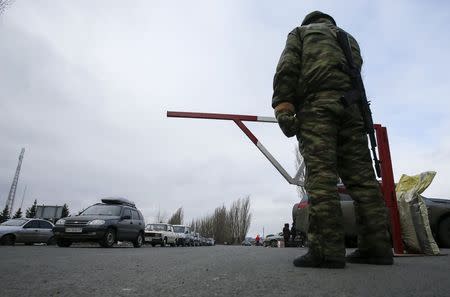 A member of the armed forces of the separatist self-proclaimed Donetsk People's Republic guards a border crossing point as cars queue to drive into the territory of Russia outside the village of Uspenka, Donetsk region, February 8, 2015. REUTERS/Maxim Shemetov