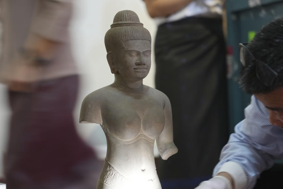 Cambodian museum staff members prepare an artifact statue as it returned from U.S to Cambodia, before an official ceremony at the Cambodian National Museum in Phnom Penh Cambodia, Thursday, July 4, 2024. Cambodia on Thursday officially organized a welcome ceremony for the arrival of more than a dozen rare Angkor era sculptures from New York's Metropolitan Museum of Art that were tied to an art dealer and collector accused of running a huge antiquities trafficking network out of Southeast Asia. (AP Photo/Heng Sinith)