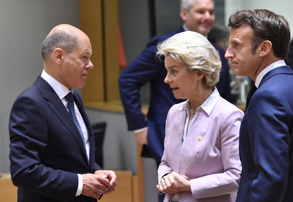 European Commission President Ursula von der Leyen, center, and French President Emmanuel Macron, right, speak with German Chancellor Olaf Scholz during a round table meeting at an EU summit in Brussels, Thursday, June 23, 2022. European Union leaders are expected to approve Thursday a proposal to grant Ukraine a EU candidate status, a first step on the long toward membership. The stalled enlargement process to include Western Balkans countries in the bloc is also on their agenda at the summit in Brussels. (AP Photo/Geert Vanden Wijngaert)