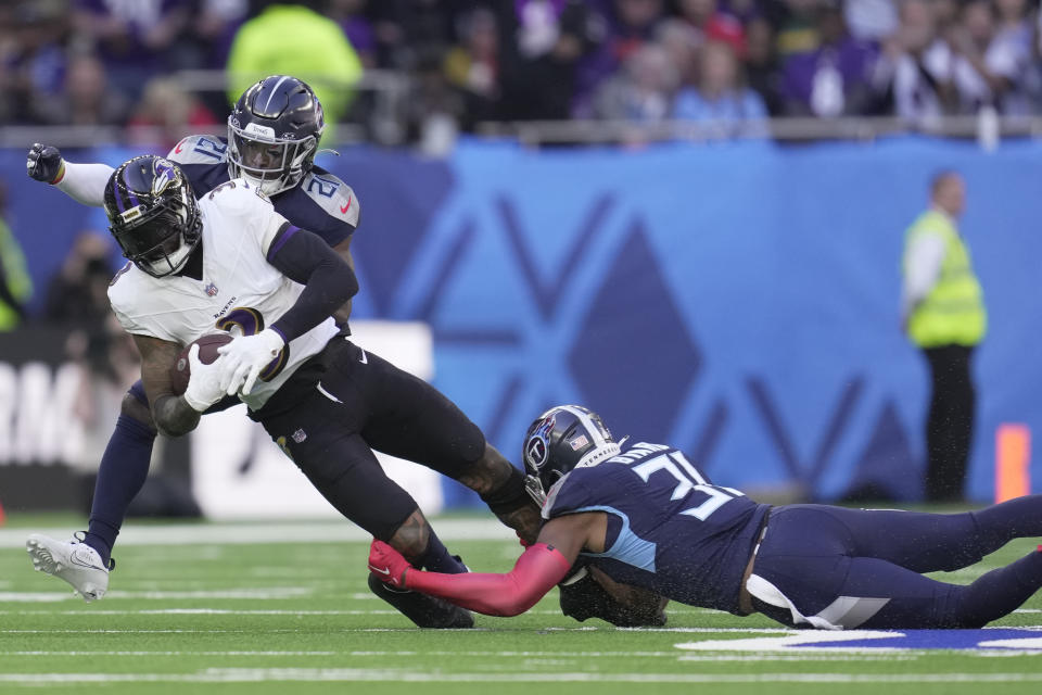 Baltimore Ravens wide receiver Odell Beckham Jr., left, is tackled by Tennessee Titans safety Kevin Byard, right, and cornerback Roger McCreary, behind, during the first half of an NFL football game Sunday, Oct. 15, 2023, at the Tottenham Hotspur stadium in London. (AP Photo/Kin Cheung)