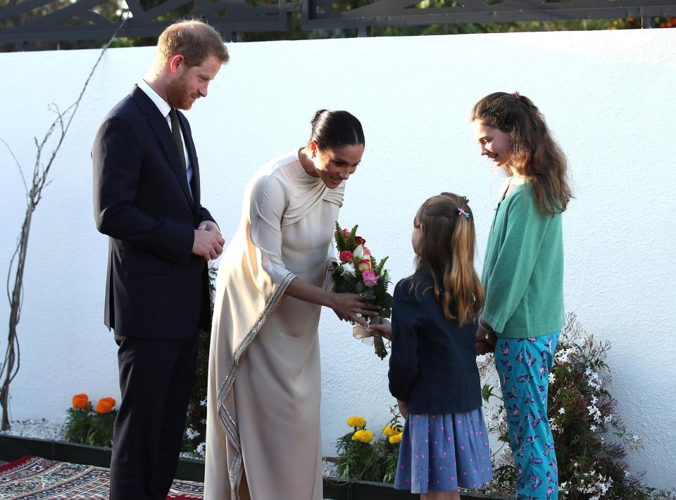Harry and Meghan were all smiles when the British Ambassador to Morroco's daughters, Orla Reilly, 12, and Elsa Reilly, 8, greeted the royals with flowers before a reception in Rabat.