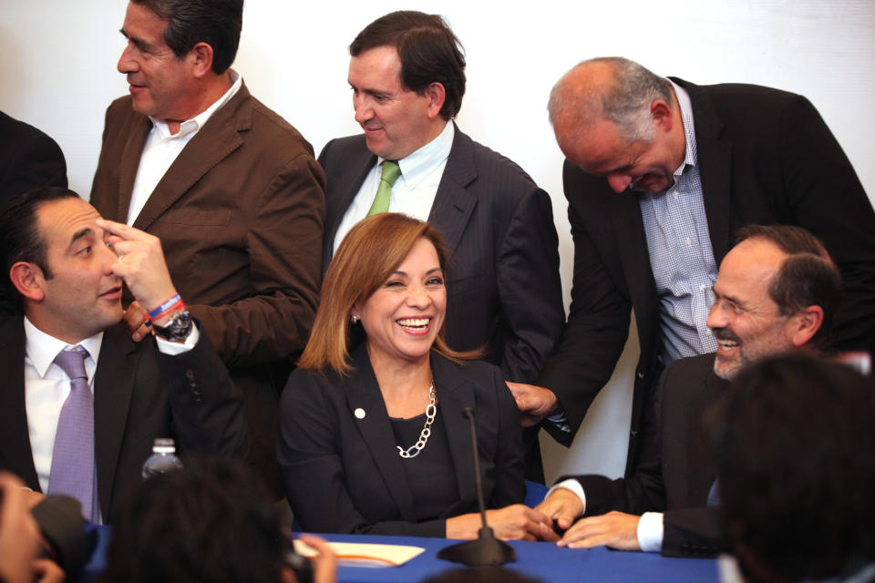 Josefina Vazquez Mota, presidential candidate for the ruling National Action Party, PAN, bottom row center, laughs during a news conference with top members of her party in Mexico City, Monday April 9, 2012. The presidential candidate of Mexico's ruling party announced Monday that she will adopt a more aggressive strategy in what she called a "course correction" following a series of missteps in the first week of campaigning. Bottom row at left is Roberto Gil and bottom row at right is Gutavo Madero. Top row from left to right is Diodoro Carrasco, Rafael Gimenez and Juan Ignacio Zavala. (AP Photo/Alexandre Meneghini)
