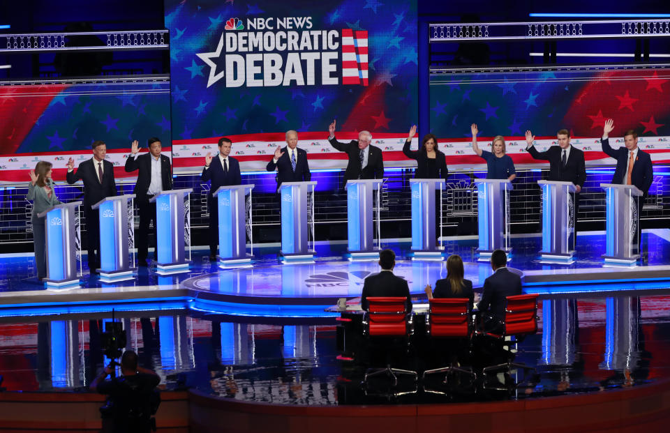 Democratic presidential candidates left to right, author Marianne Williamson, former Colorado Gov. John Hickenlooper, entrepreneur Andrew Yang, South Bend Mayor, Pete Buttigieg, former Vice-President Joe Biden, Sen. Bernie Sanders, I-Vt, Sen. Kamala Harris, D-Calif., Sen. Kristen Gillibrand, D-NY., former Colorado Sen. Michael Bennet and Rep. Eric Swalwell, D-Calif. raise their hands when asked if they would provide healthcare for undocumented immigrants, during the Democratic primary debate hosted by NBC News at the Adrienne Arsht Center for the Performing Arts, Thursday, June 27, 2019, in Miami. (AP Photo/Wilfredo Lee)