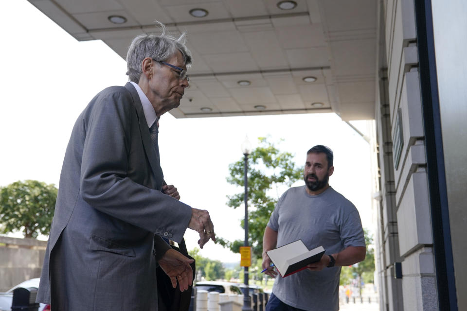A man asks for an autograph as author Stephen King arrives at federal court before testifying for the Department of Justice as it bids to block the proposed merger of two of the world's biggest publishers, Penguin Random House and Simon & Schuster, Tuesday, Aug. 2, 2022, in Washington. (AP Photo/Patrick Semansky)