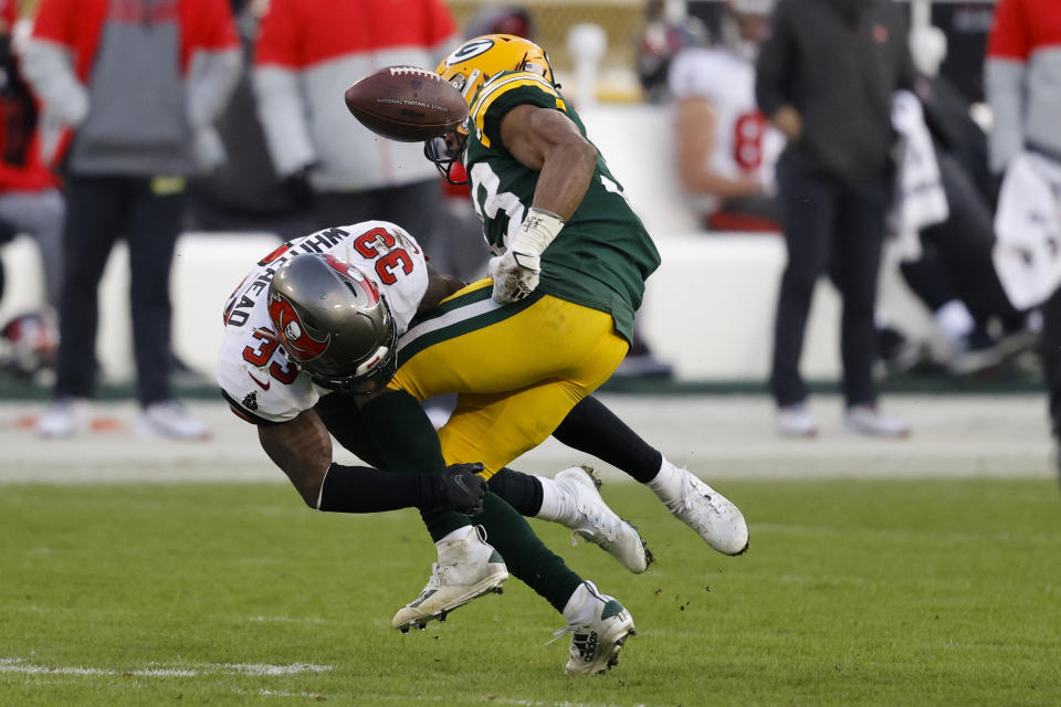Green Bay Packers' Aaron Jones (33) fumbles after being hit by Tampa Bay Buccaneers' Jordan Whitehead (33) during the second half of the NFC championship NFL football game in Green Bay, Wis., Sunday, Jan. 24, 2021. (AP Photo/Jeffrey Phelps)