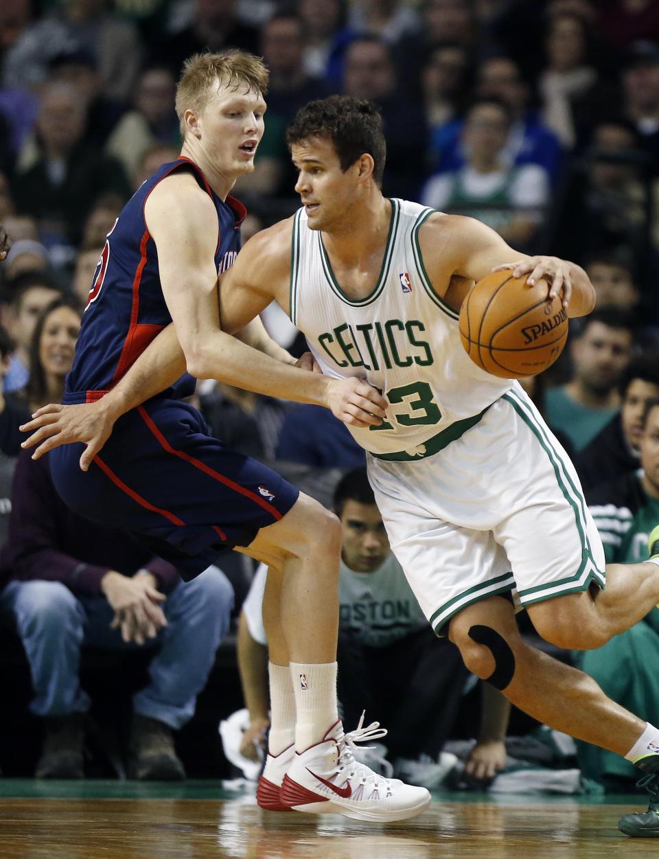 Boston Celtics' Kris Humphries, right, drives past Detroit Pistons' Kyle Singler, left, in the first quarter of an NBA basketball game in Boston, Sunday, March 9, 2014. (AP Photo/Michael Dwyer)