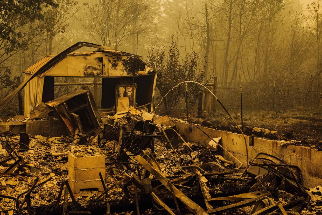 Water continues to flow from a pipe amid the charred remains of homes and businesses after the passage of the Santiam fire in Gates, Oregon, on Sept. 10. (Photo: KATHRYN ELSESSER via Getty Images)