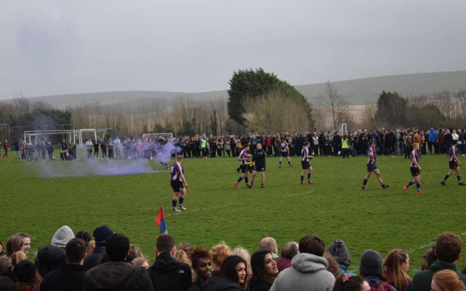 A flare was thrown onto the pitch during a rugby varsity match as police struggled to control supporters - Credit: The Tab