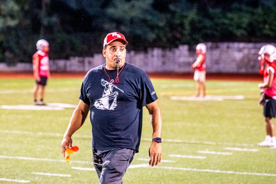 New Bedford head coach Mark DeBrito runs preseason training.