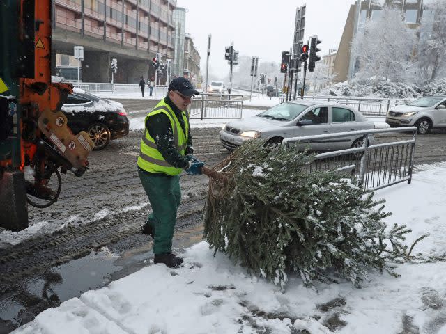 A Christmas tree is collected in the snow in Glasgow (Andrew Milligan/PA)