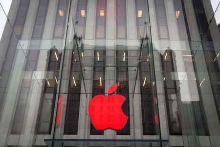 The Apple logo is illuminated in red at the Apple Store on 5th Avenue to mark World AIDS Day, in the Manhattan borough of New York December 1, 2014. REUTERS/Carlo Allegri