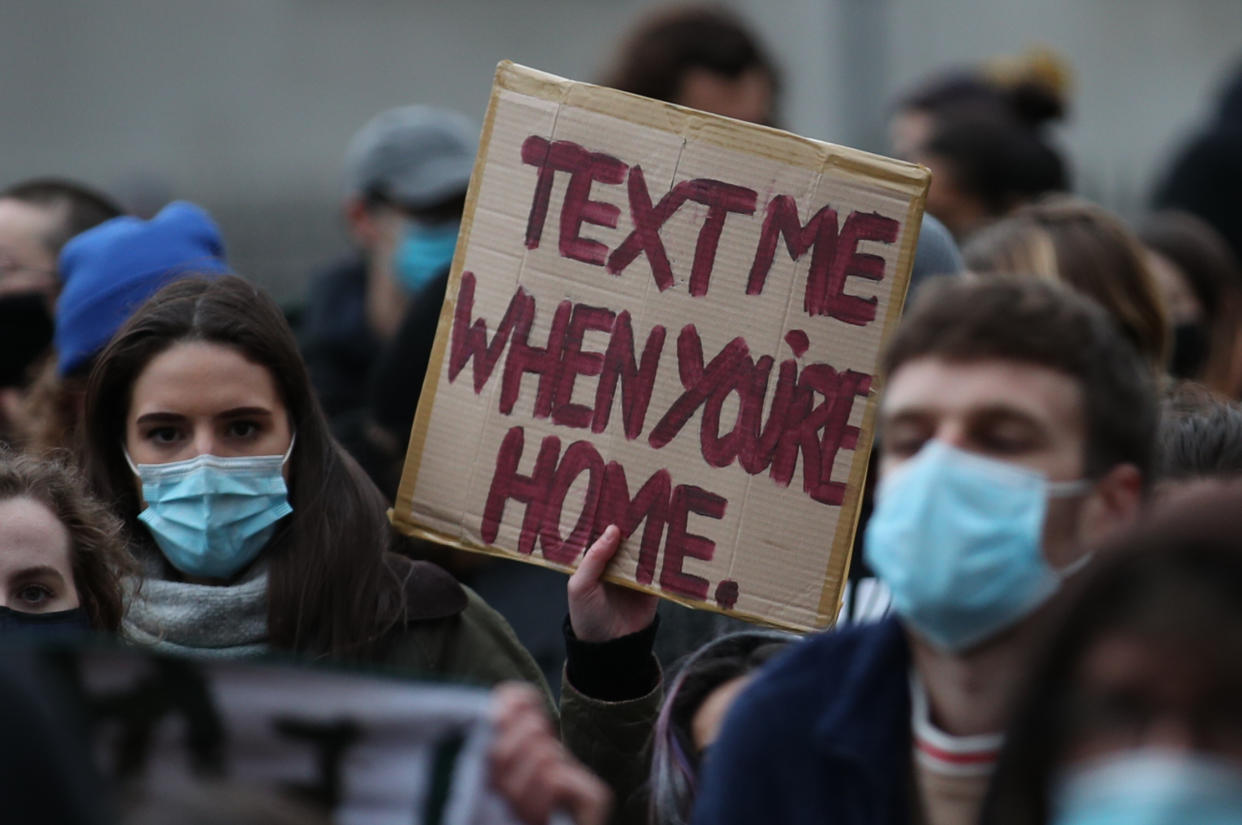 A person holds up a placard amongst a crowd of people in Parliament Square in London, the day after clashes between police and crowds who gathered on Clapham Common on Saturday night to remember Sarah Everard. The Metropolitan Police has faced intense criticism for its handling of the vigil, with officers accused of 