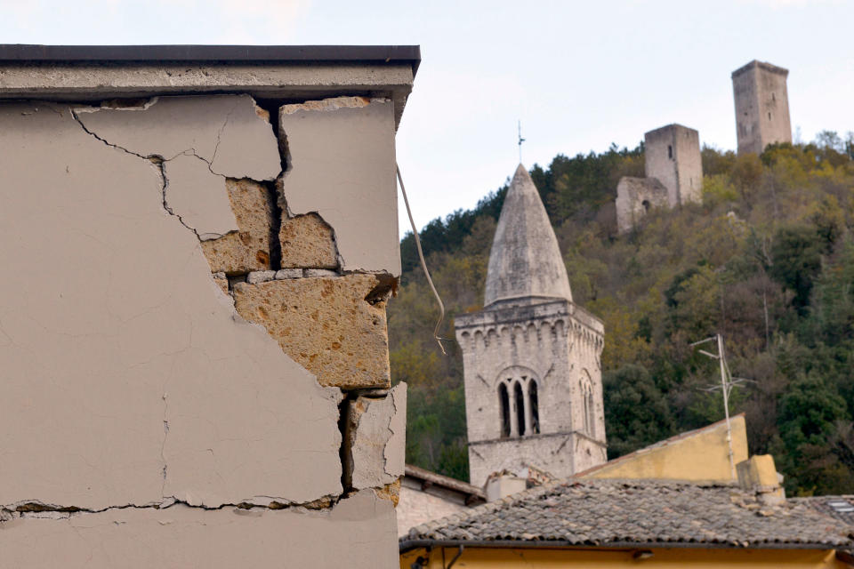 A damaged building frames more ancient towers