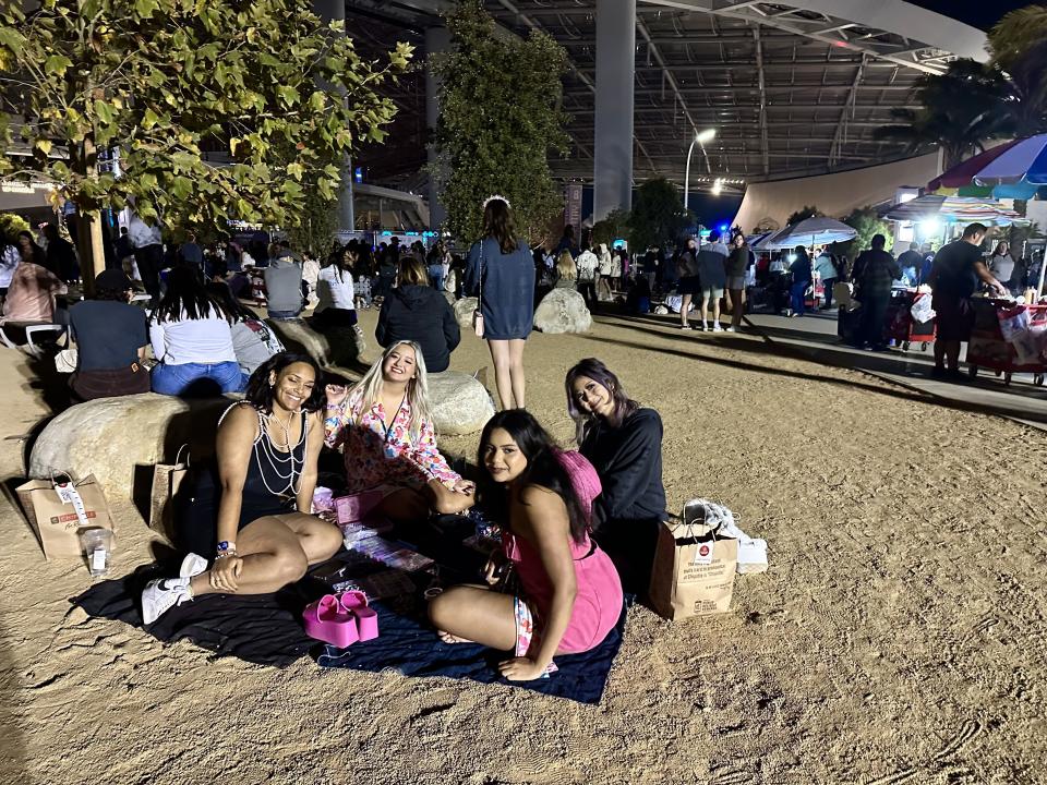 A group of friends brought a blanket and friendship bracelets to make during the show in the park on the south side of SoFi Stadium in Inglewood, Calif. on Aug. 11, 2023. | Sarah Gambles, Deseret News