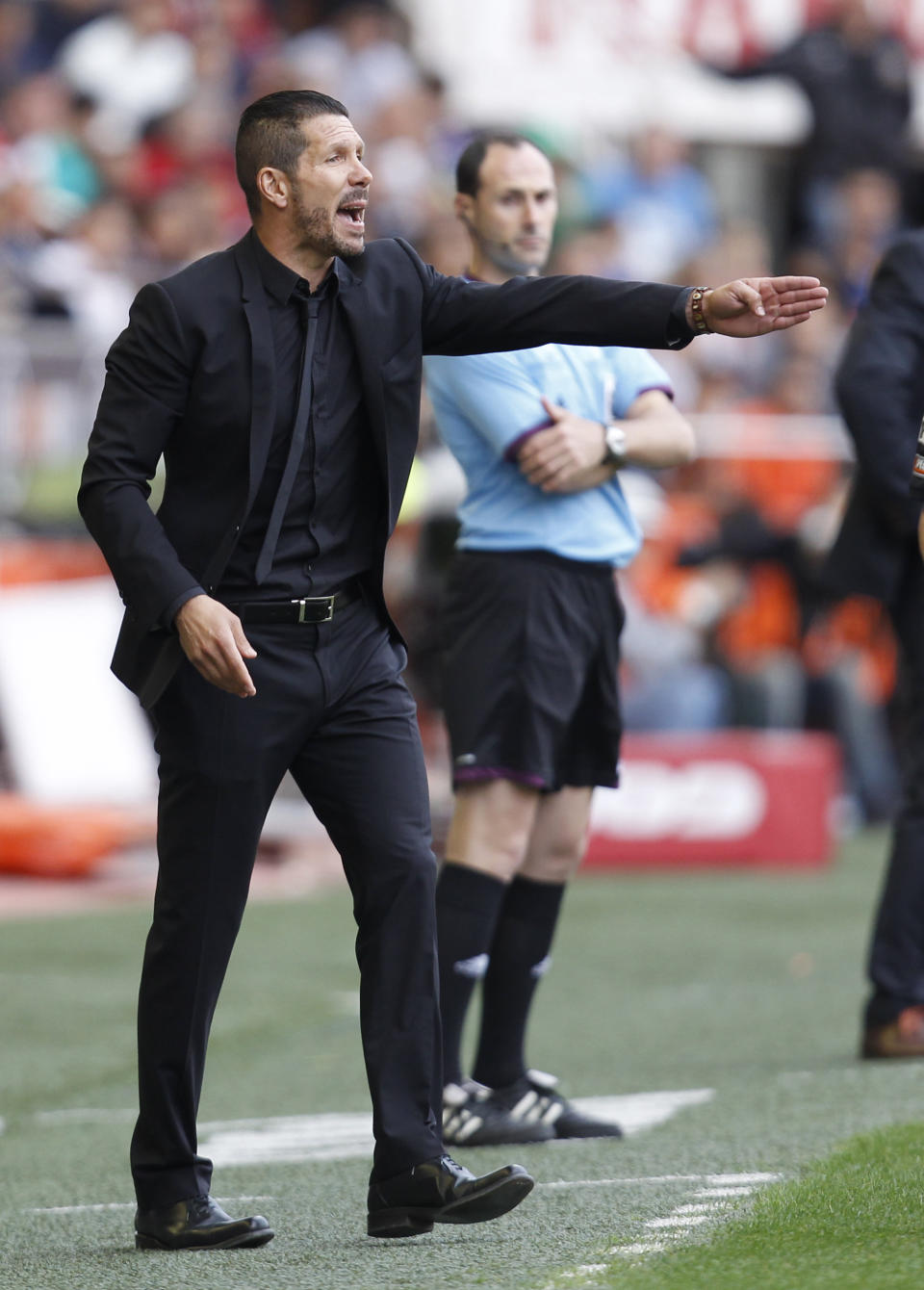 Atletico's de Madrid coach Diego Simeone from Argentina gesture to their players during a Spanish La Liga soccer match against Valencia at the Mestalla stadium in Valencia, Spain, on Sunday, April 27, 2014. (AP Photo/Alberto Saiz)