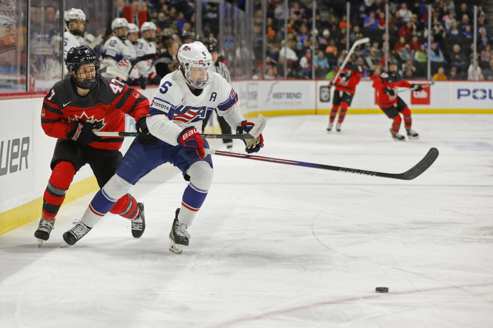 Canada forward Jamie Lee Rattray (47) chases United States defenseman Megan Keller (5) for the puck in the first period in a women's Rivalry Series hockey game Sunday, Feb. 11, 2024, in St. Paul, Minn. (AP Photo/Bruce Kluckhohn)