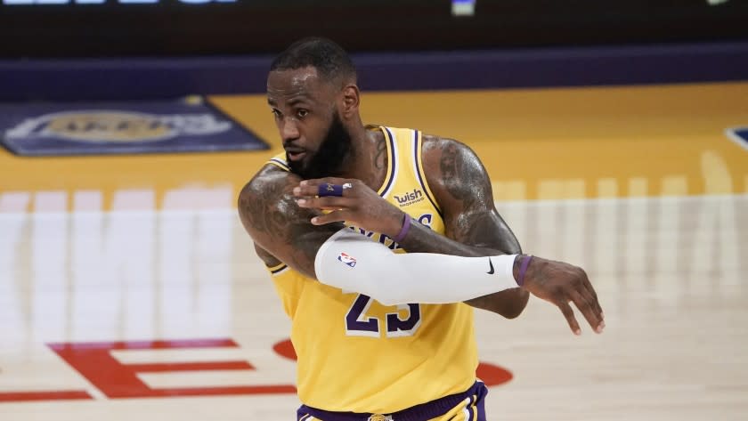 Los Angeles Lakers' LeBron James passes the ball during the first half of an NBA basketball game.