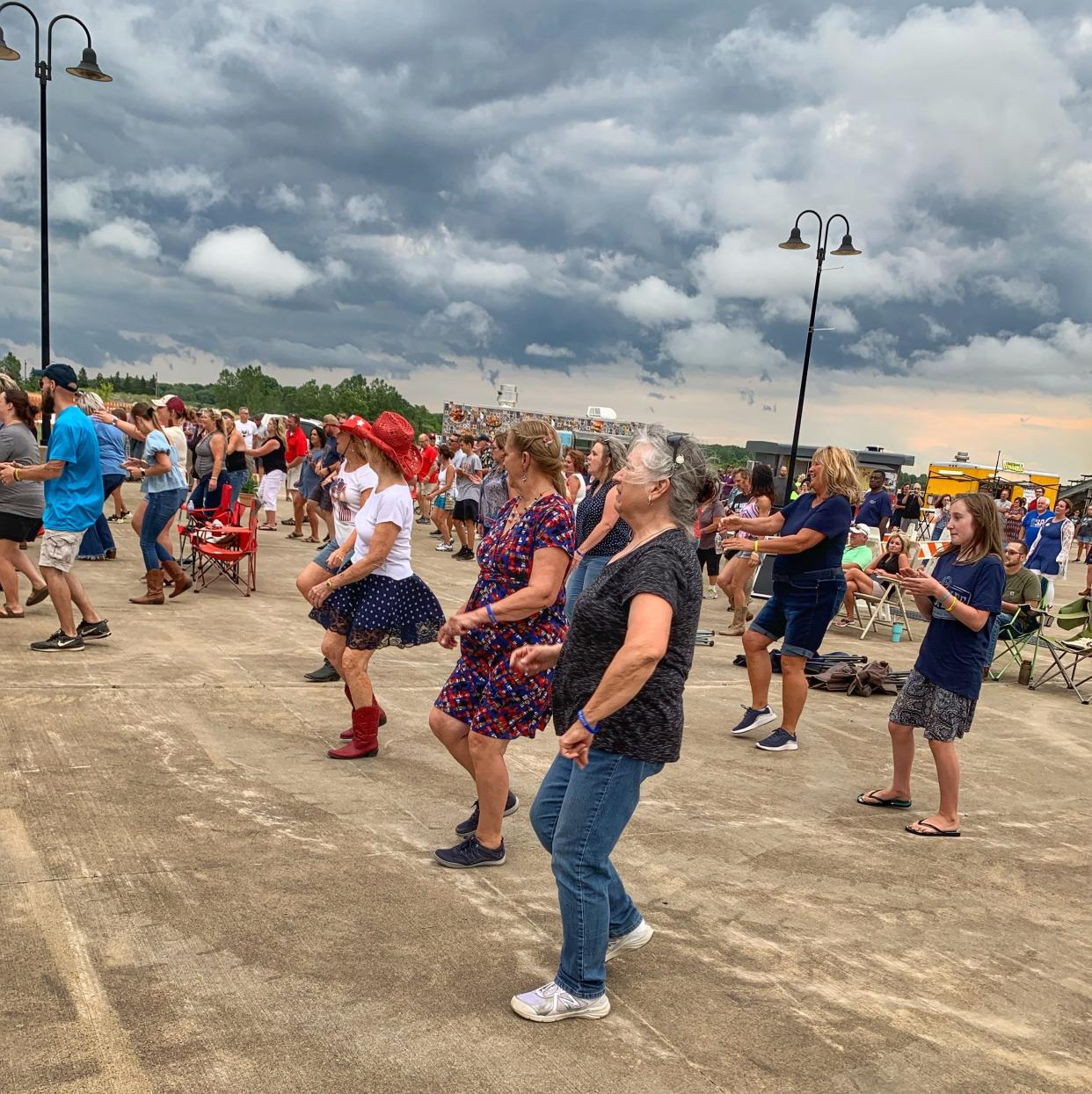 Concert-goers dance "The Electric Slide" in an attempt to break a new world record for line dancing. The effort in Mansfield Friday night fell about 18,000 participants short of the world record set in China with 18,441 people.