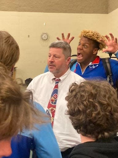 Dion Stutts, back, makes a funny face behind MUS wrestling coach Chris Lewis, after a wrestling match. SUBMITTED