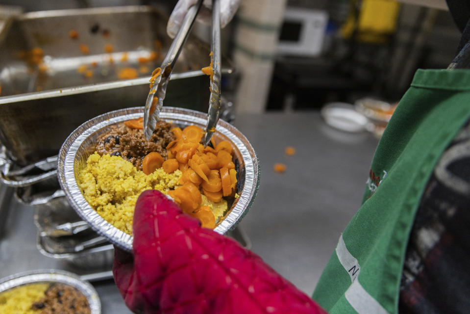 A volunteer prepares a lunch box at Community Help in Park Slope, a soup kitchen and food pantry better known as CHiPS, on Friday, June 16, 2023 in New York. Charitable giving in the United States declined in 2022. The downturn in giving has led to issues at CHiPS, as it has in many charities across the country. (AP Photo/Jeenah Moon)