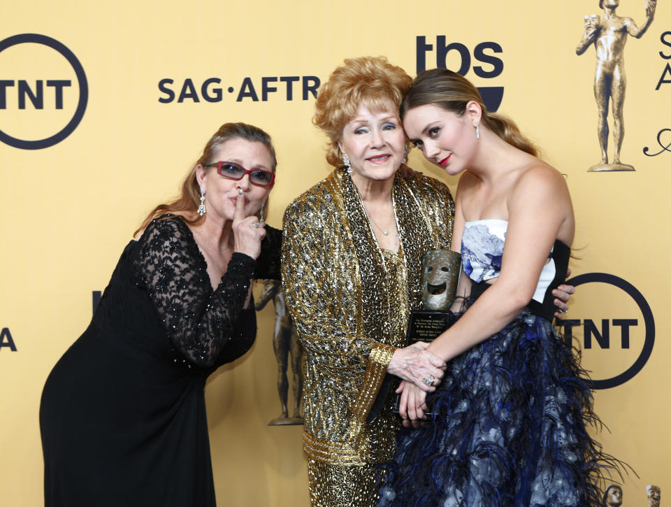 Actress Debbie Reynolds poses backstage with her Lifetime Achievement award with her granddaughter Billie Catherine (R) and actress Carrie Fisher (L) at the 21st annual Screen Actors Guild Awards in Los Angeles, California January 25, 2015.  REUTERS/Mike Blake (UNITED STATES - Tags: ENTERTAINMENT) (SAGAWARDS-BACKSTAGE)
