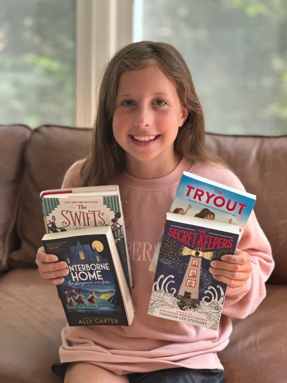 Ten-year-old Harper poses with her Mystery Box book selections curated by "The Novel Neighbor."